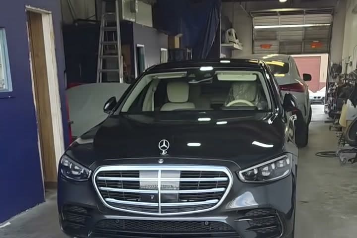 A black Mercedes-Benz S-Class parked inside the shop's bay