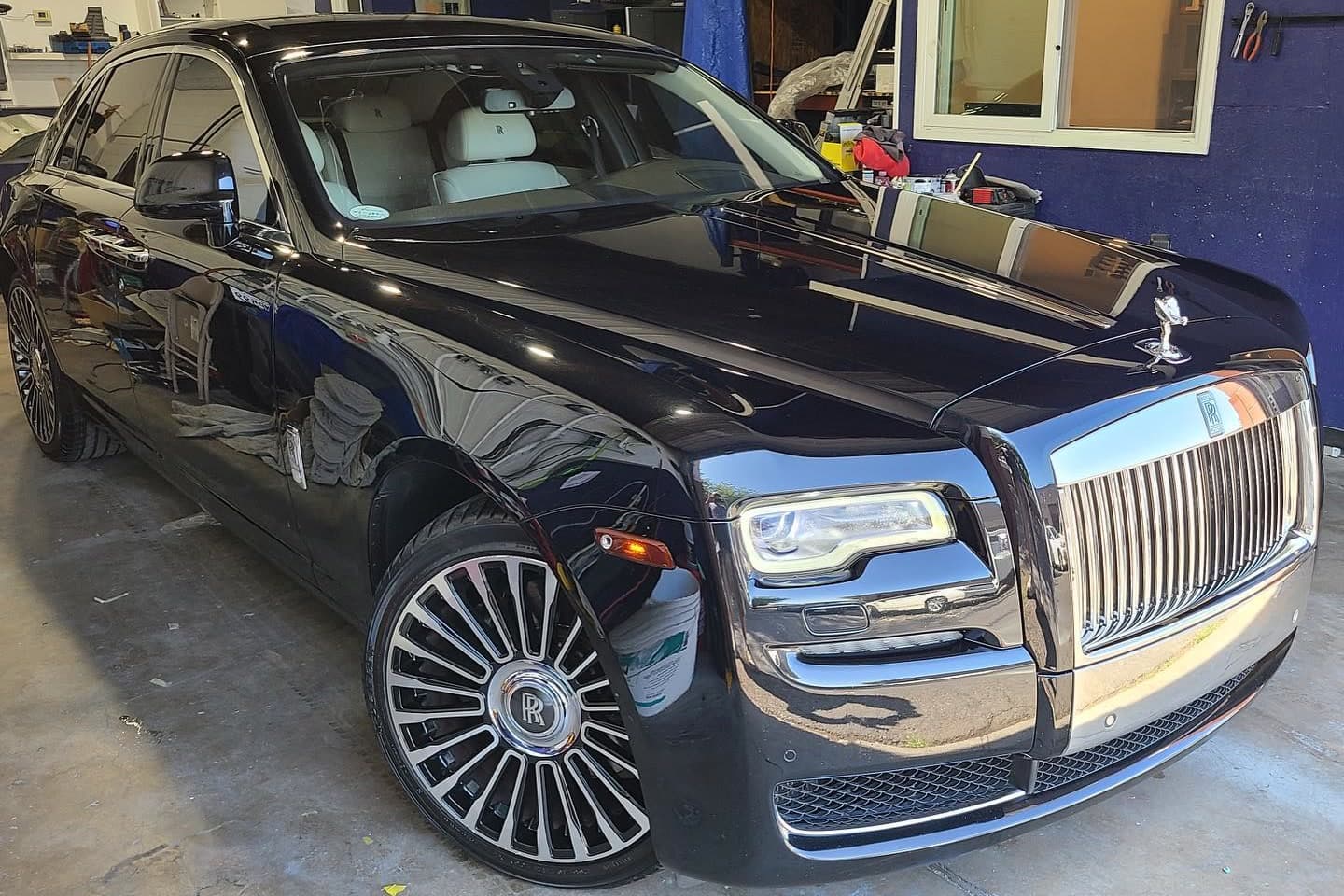 A black Rolls-Royce Ghost inside the shop's bay